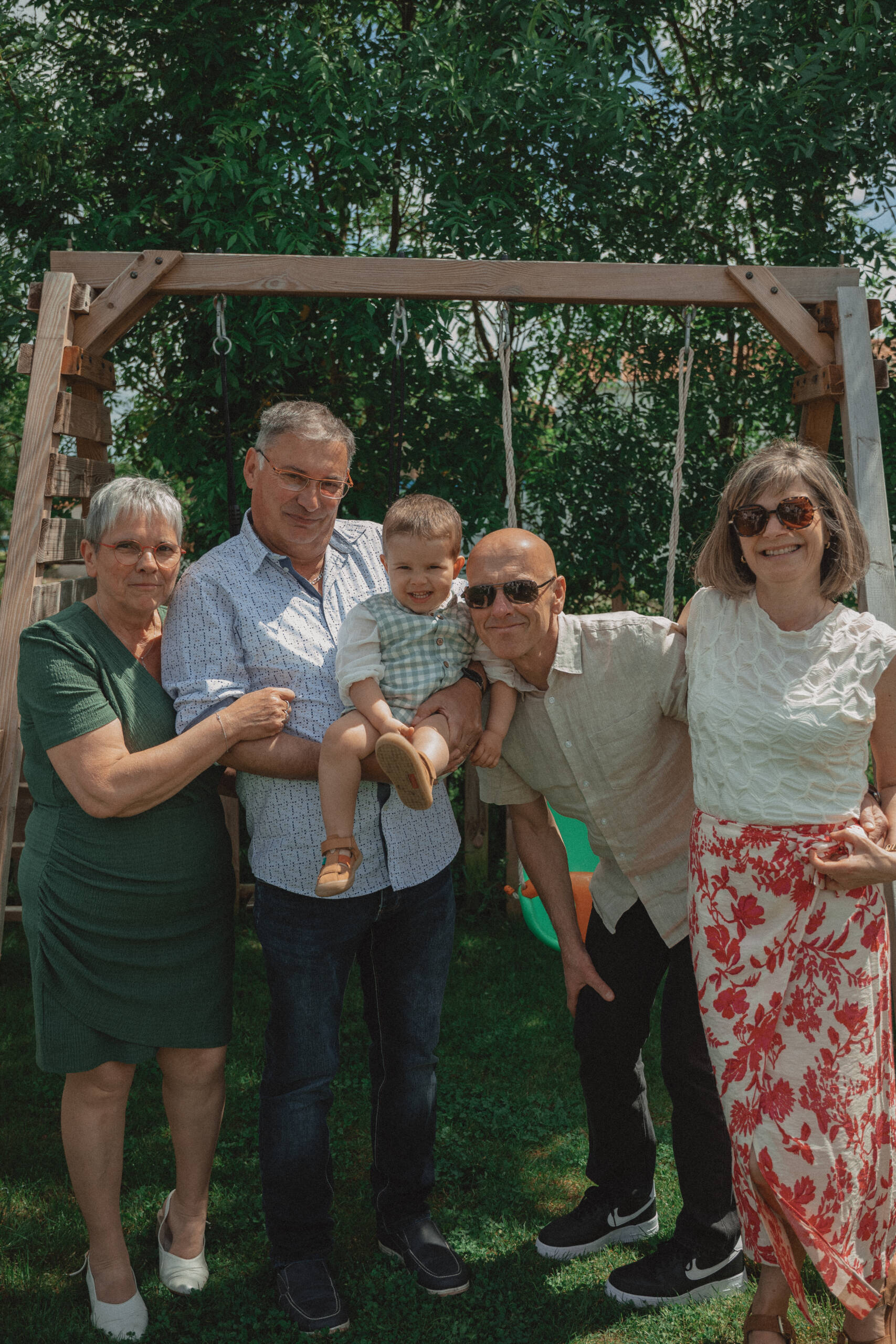 Enfant entouré de ses grands parents lors de son baptême. Image réalisée par Solène photographe.