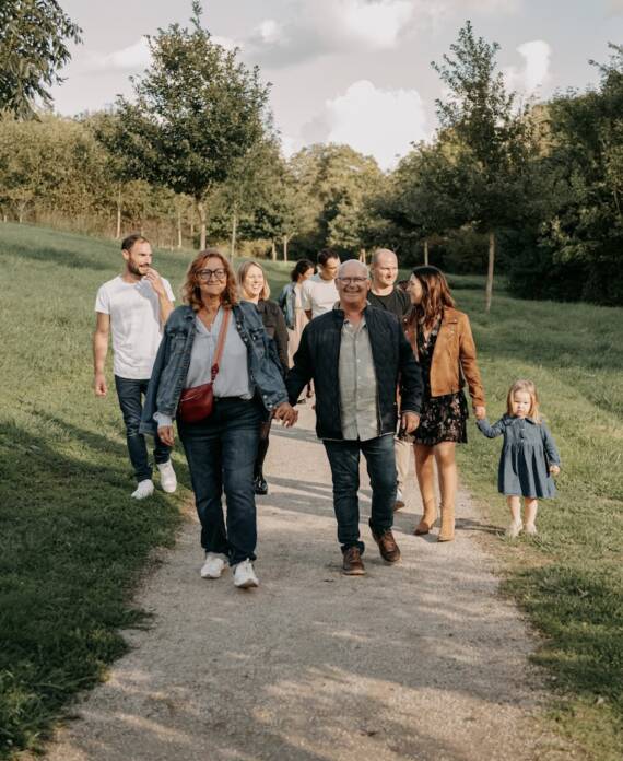 Famille intergénérationnelle marchant sur un chemin lors d’une séance photo à la Maison de la Rivière à Saint-Georges-de-Montaigu en Vendée, réalisée par Solène photographe.