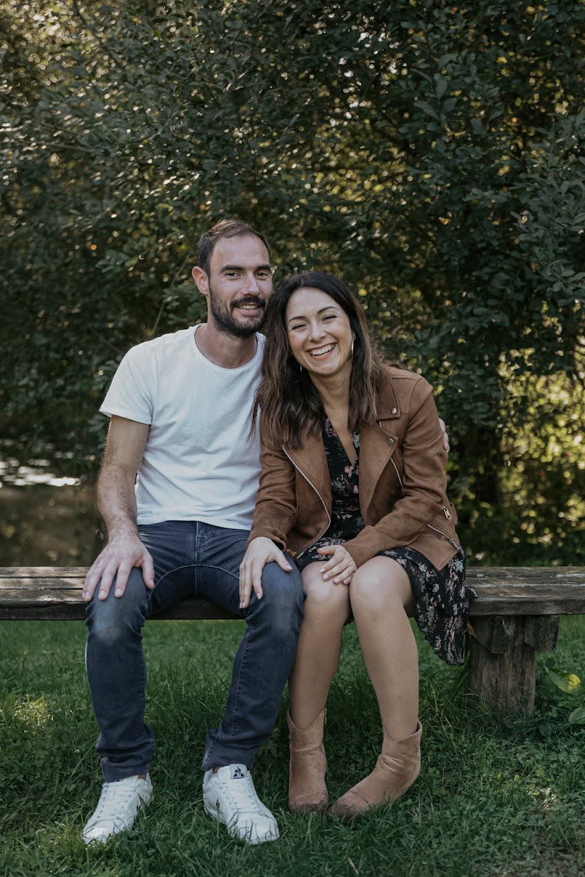 Couple riant assis sur un banc lors d’une séance photo famille à la Maison de la Rivière à Saint-Georges-de-Montaigu en Vendée, réalisée par Solène photographe.