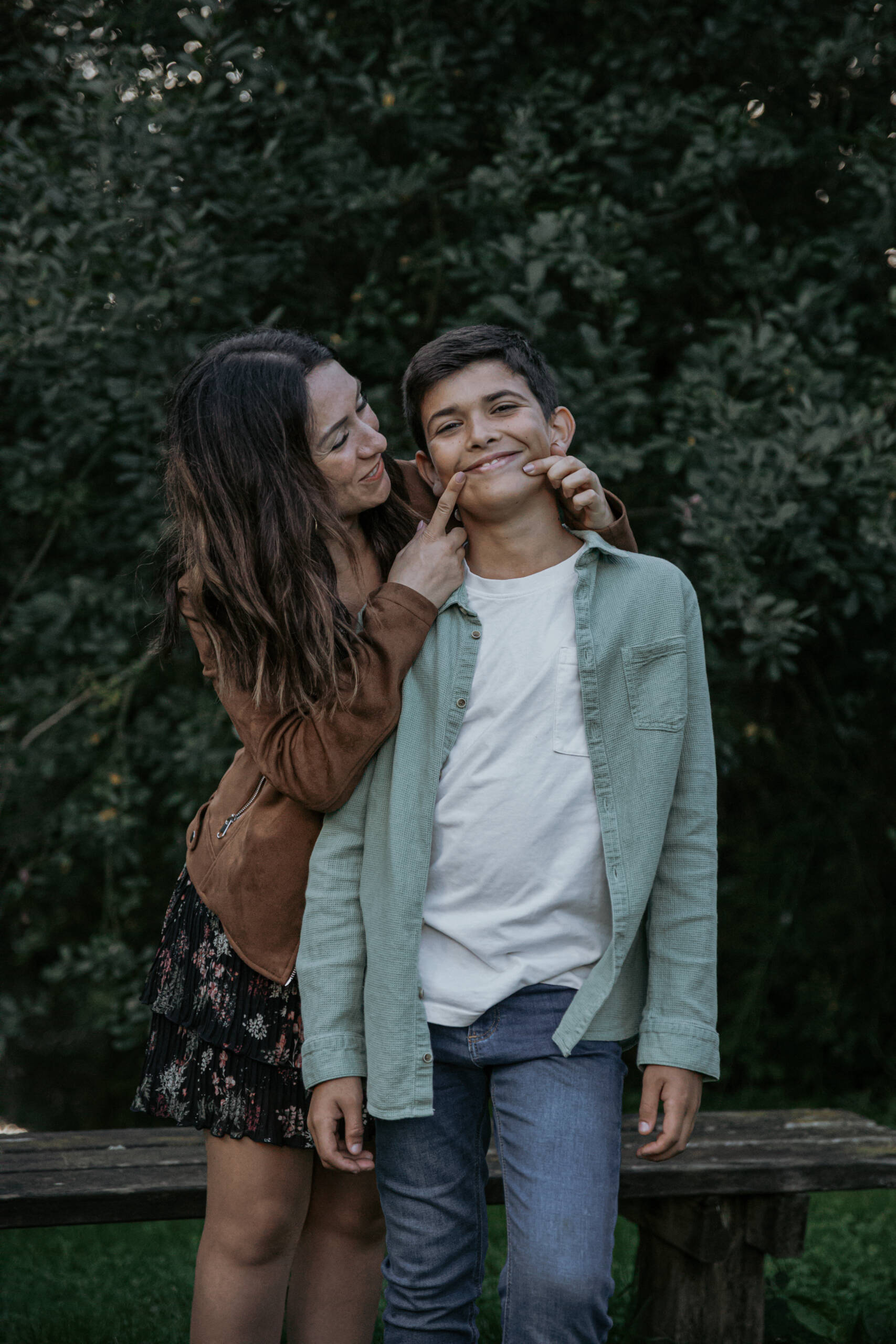 Marraine forçant son filleul à sourire lors d’une séance photo famille à la Maison de la Rivière à Saint-Georges-de-Montaigu en Vendée, réalisée par Solène photographe.