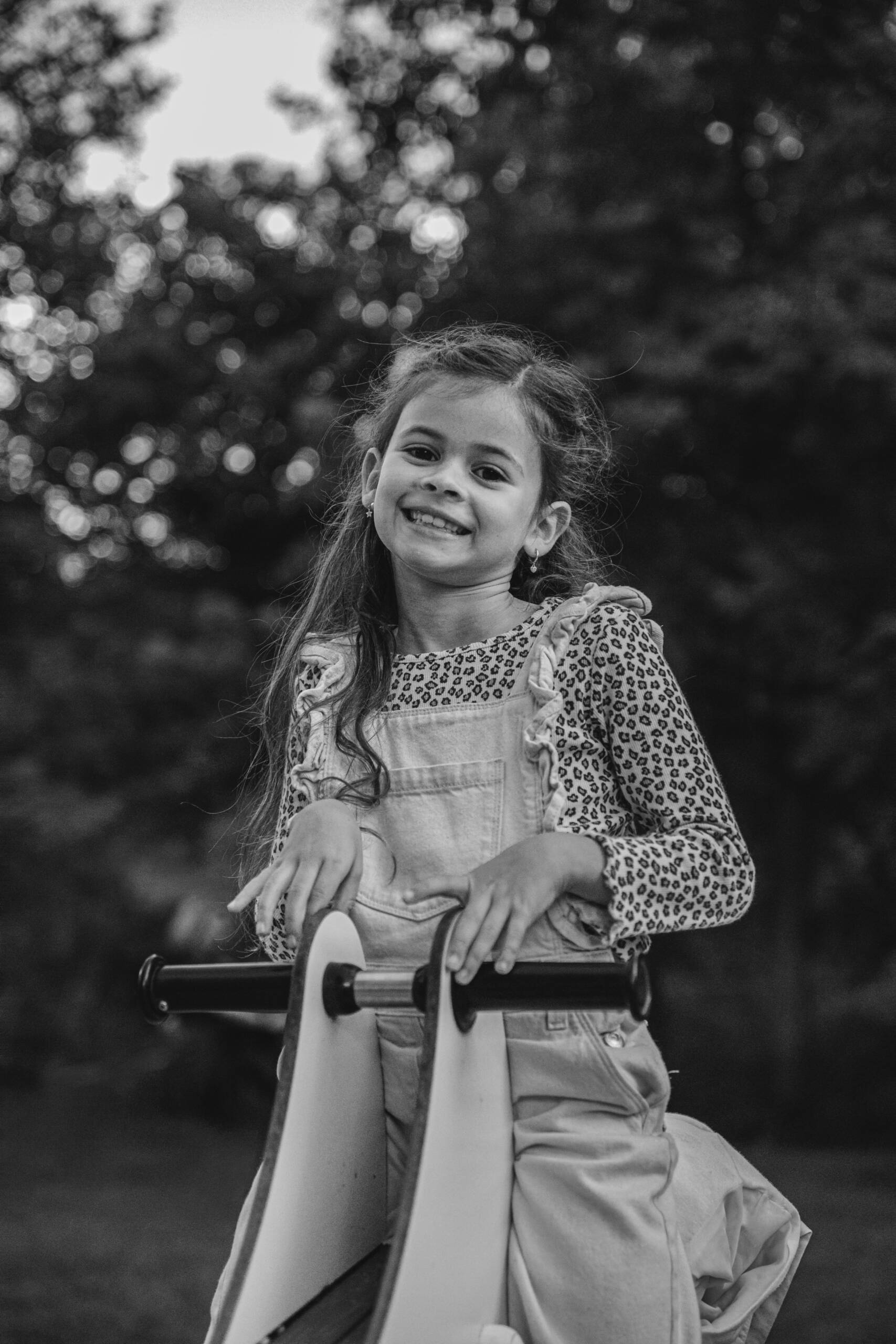 Petite fille sur un trébuchet à bascule lors d’une séance photo famille à la Maison de la Rivière à Saint-Georges-de-Montaigu, réalisée en noir et blanc par Solène photographe.