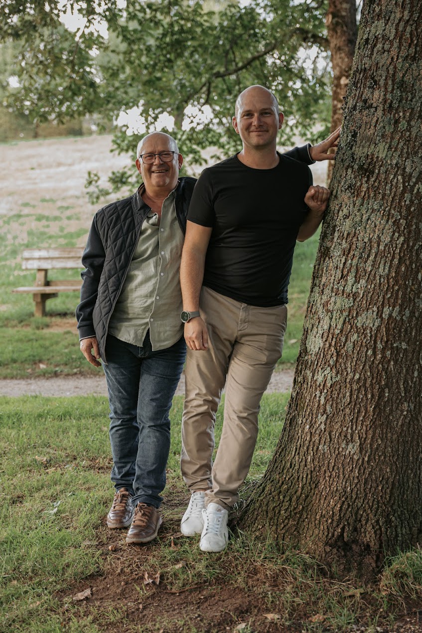 Père et fils posés contre un arbre lors d’une séance photo famille à la Maison de la Rivière à Saint-Georges-de-Montaigu en Vendée, réalisée par Solène photographe.