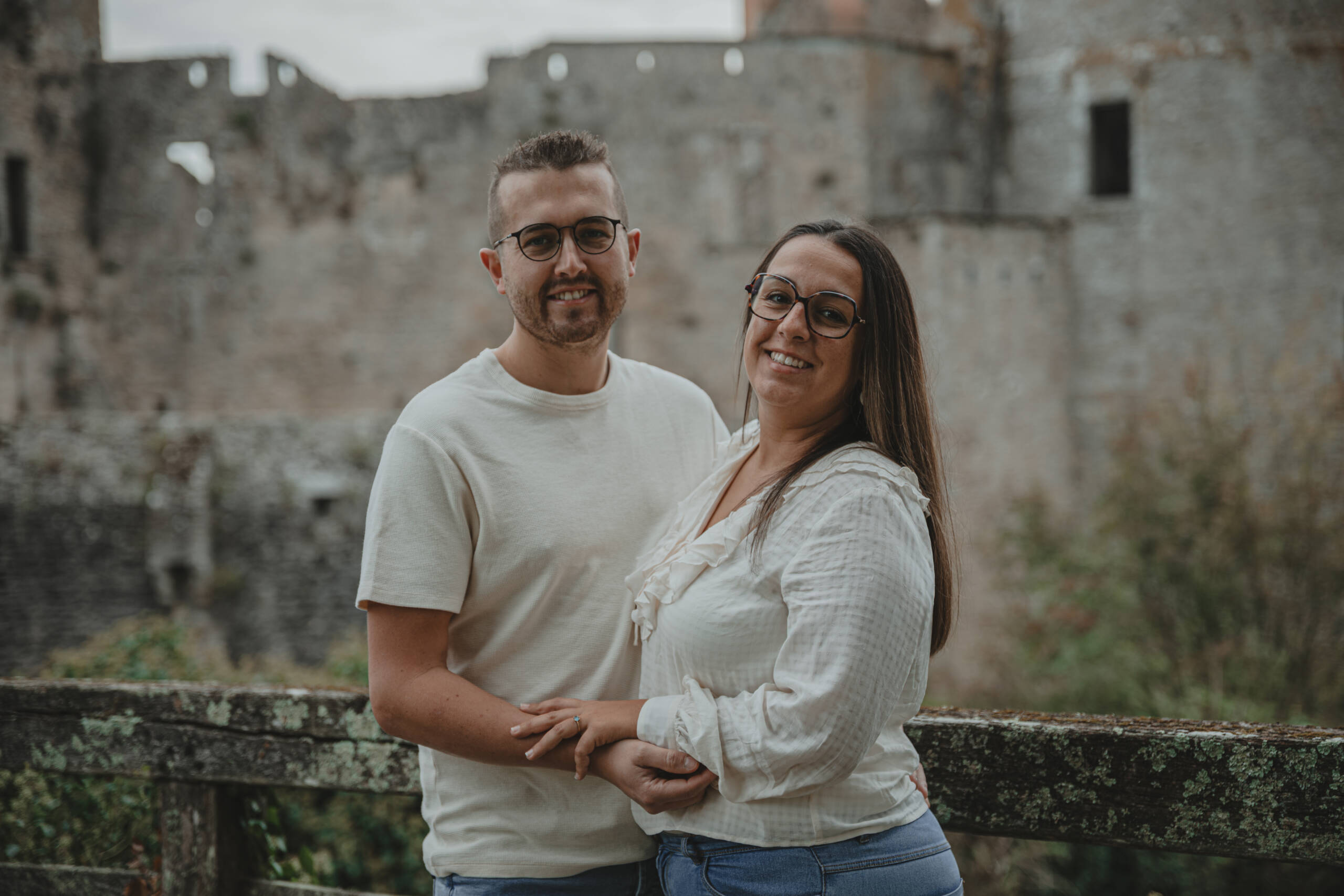 Couple souriant devant un château, lors d’une séance photo engagement à Clisson en Loire-Atlantique, réalisée par Solène photographe.