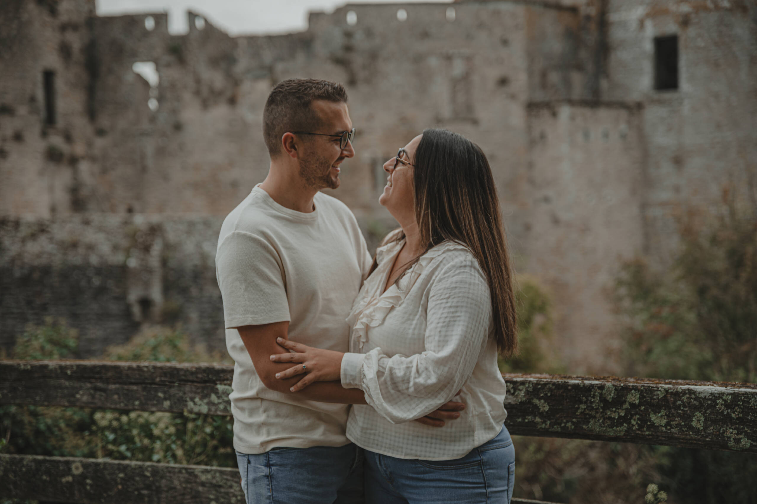 Regard complice d'un couple devant un château, lors d’une séance photo engagement à Clisson en Loire-Atlantique, réalisée par Solène photographe.