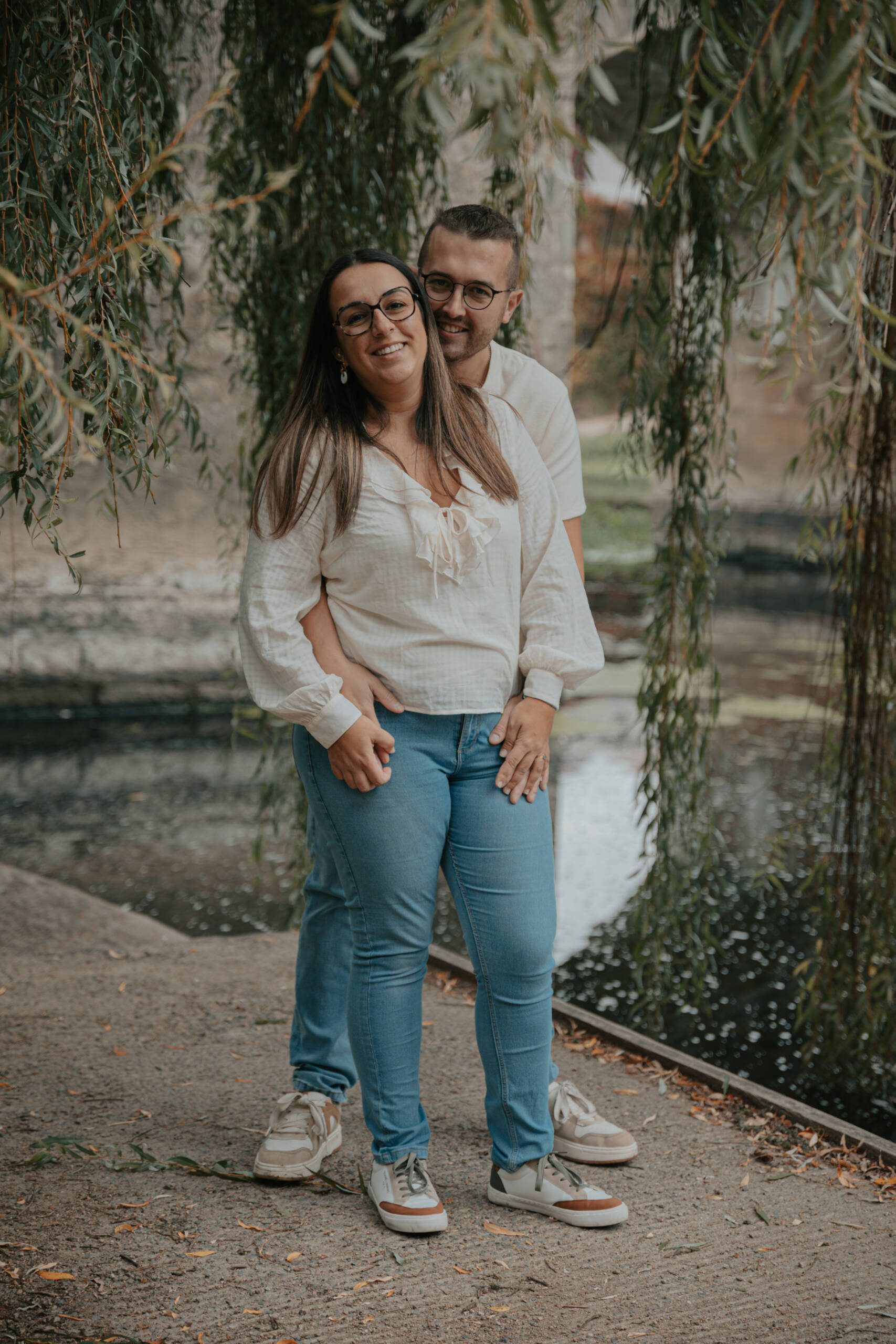 Portrait d'un couple sous un saule pleureur, lors d’une séance photo engagement à Clisson en Loire-Atlantique, réalisée par Solène photographe.