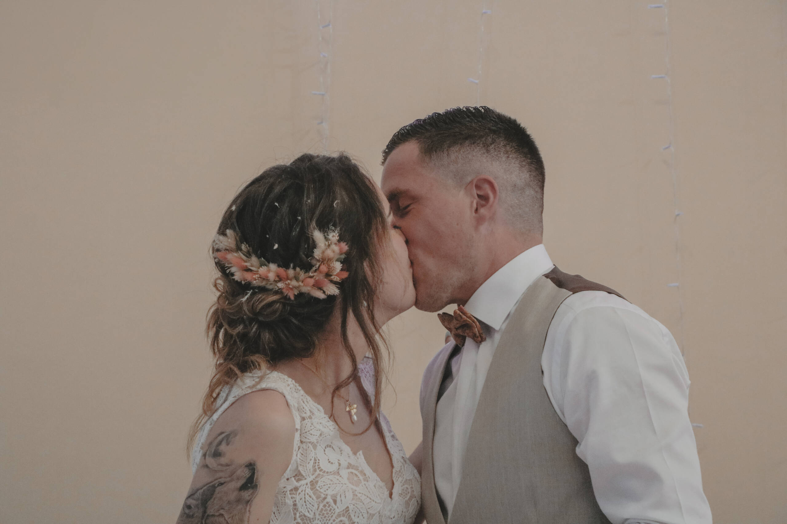 Mariés s'embrassant pendant le repas de leur mariage, réalisée par Solène photographe.