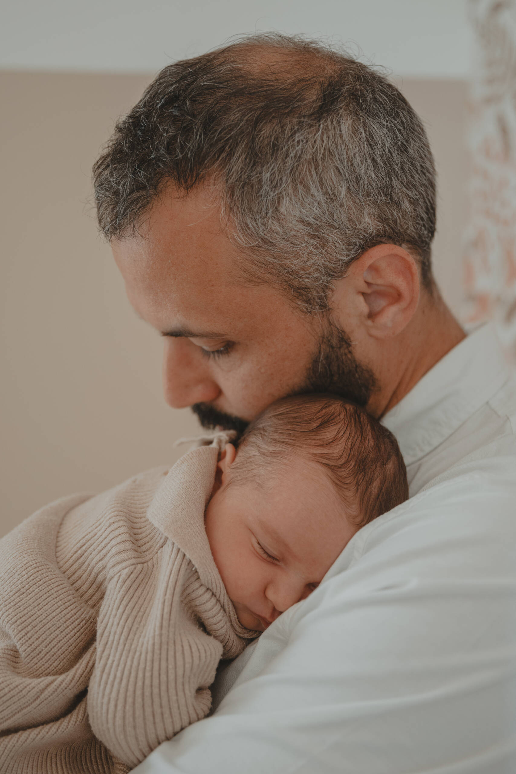 Câlin entre un nourrisson et son père, lors d’une séance photo naissance à domicile à La Ferrière en Vendée, réalisée par Solène photographe.
