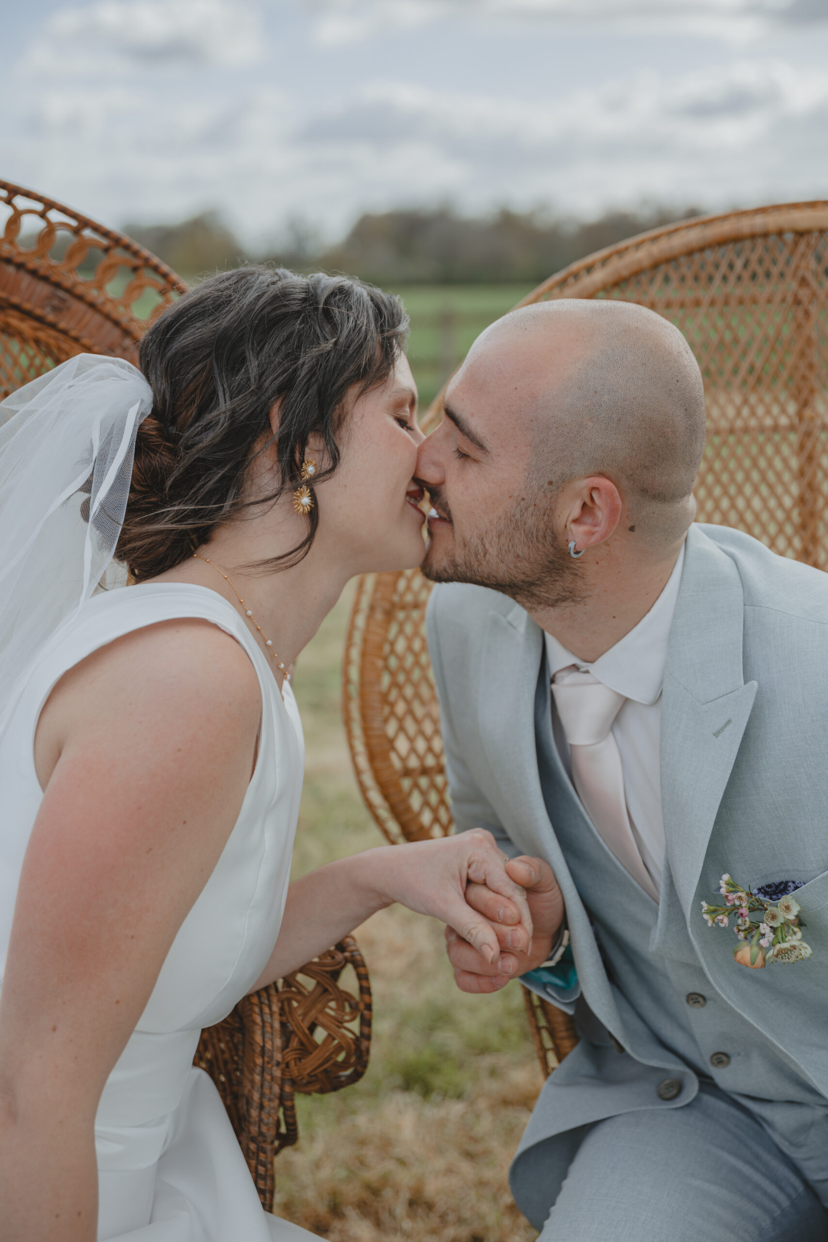 Mariés prêt à s'embrasser en se tenant la main lors d'une cérémonie laïque pendant leur mariage au Domaine Quatre Plumes aux Landes-Génusson en Vendée, réalisée par Solène photographe.
