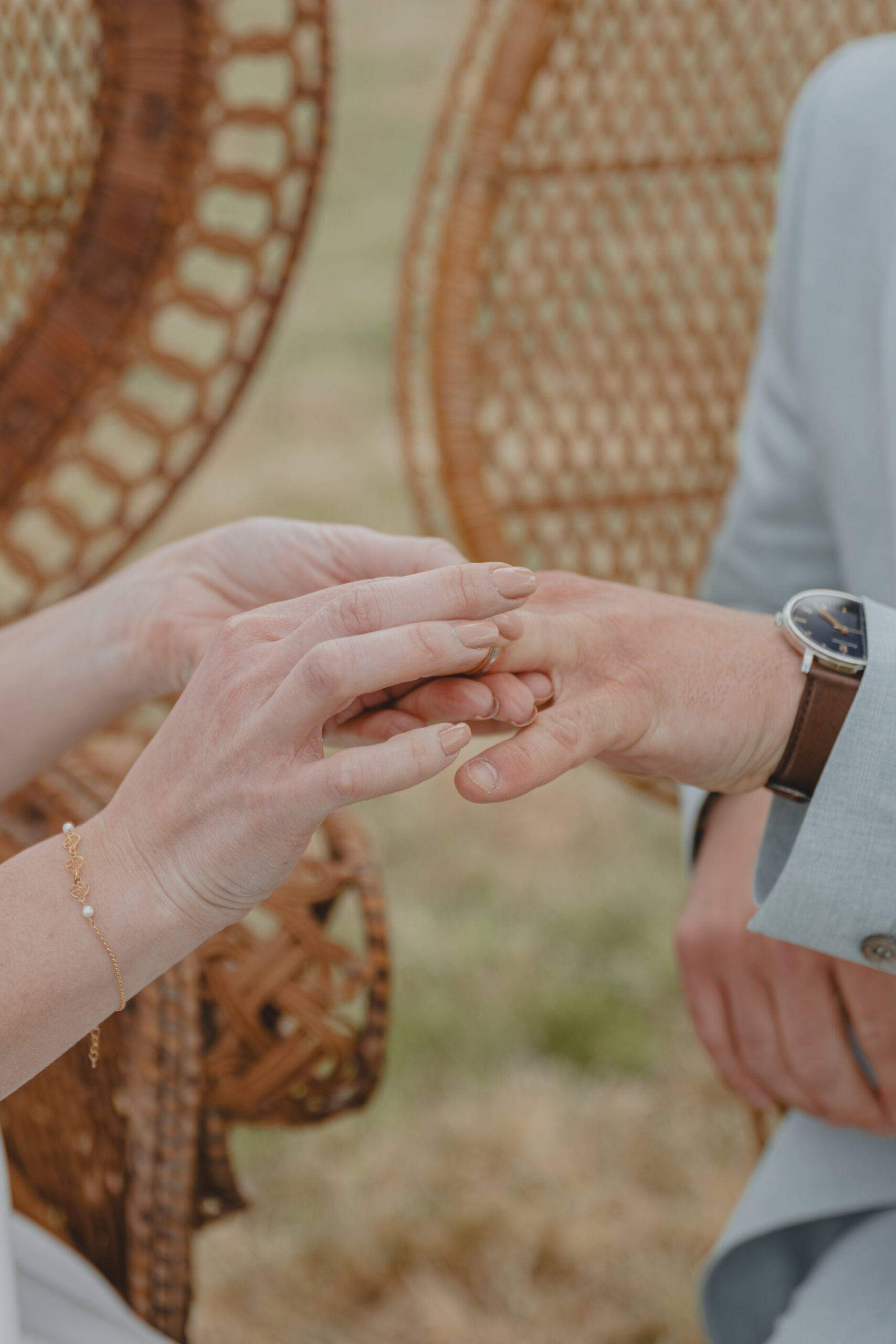 Gros plan sur un échange d'alliances lors d'une cérémonie laïque pendant un mariage au Domaine Quatre Plumes aux Landes-Génusson en Vendée, réalisée par Solène photographe.