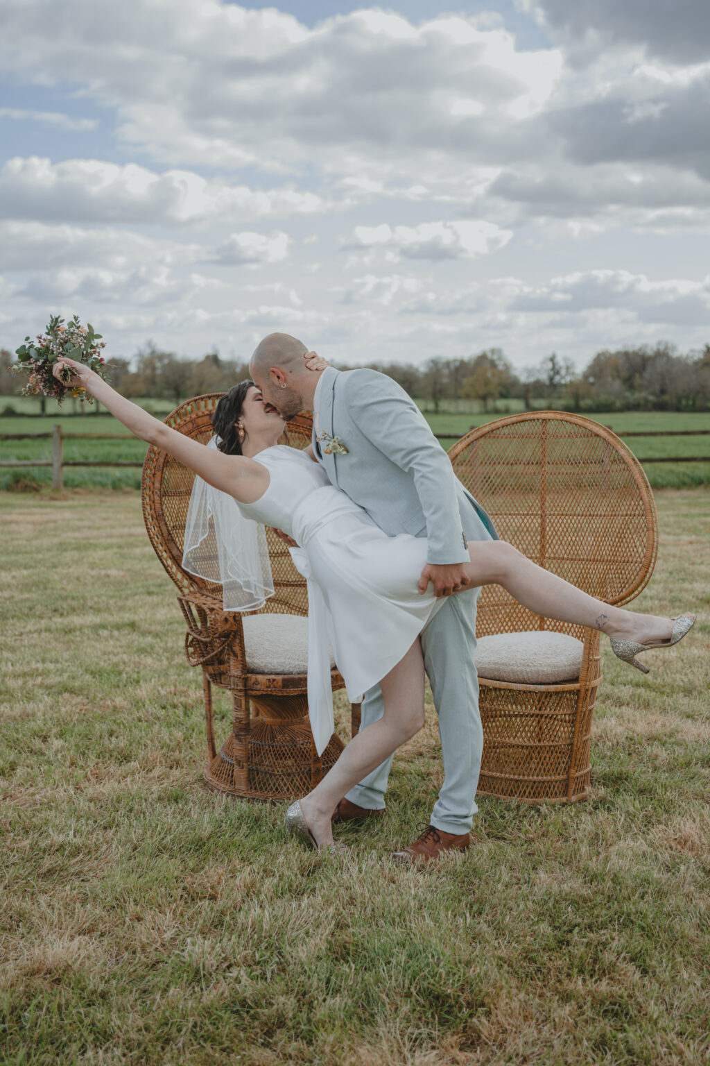 Marié renversant sa femme pour l'embrasser lors d'une cérémonie laïque pendant leur mariage au Domaine Quatre Plumes aux Landes-Génusson en Vendée, réalisée par Solène photographe.