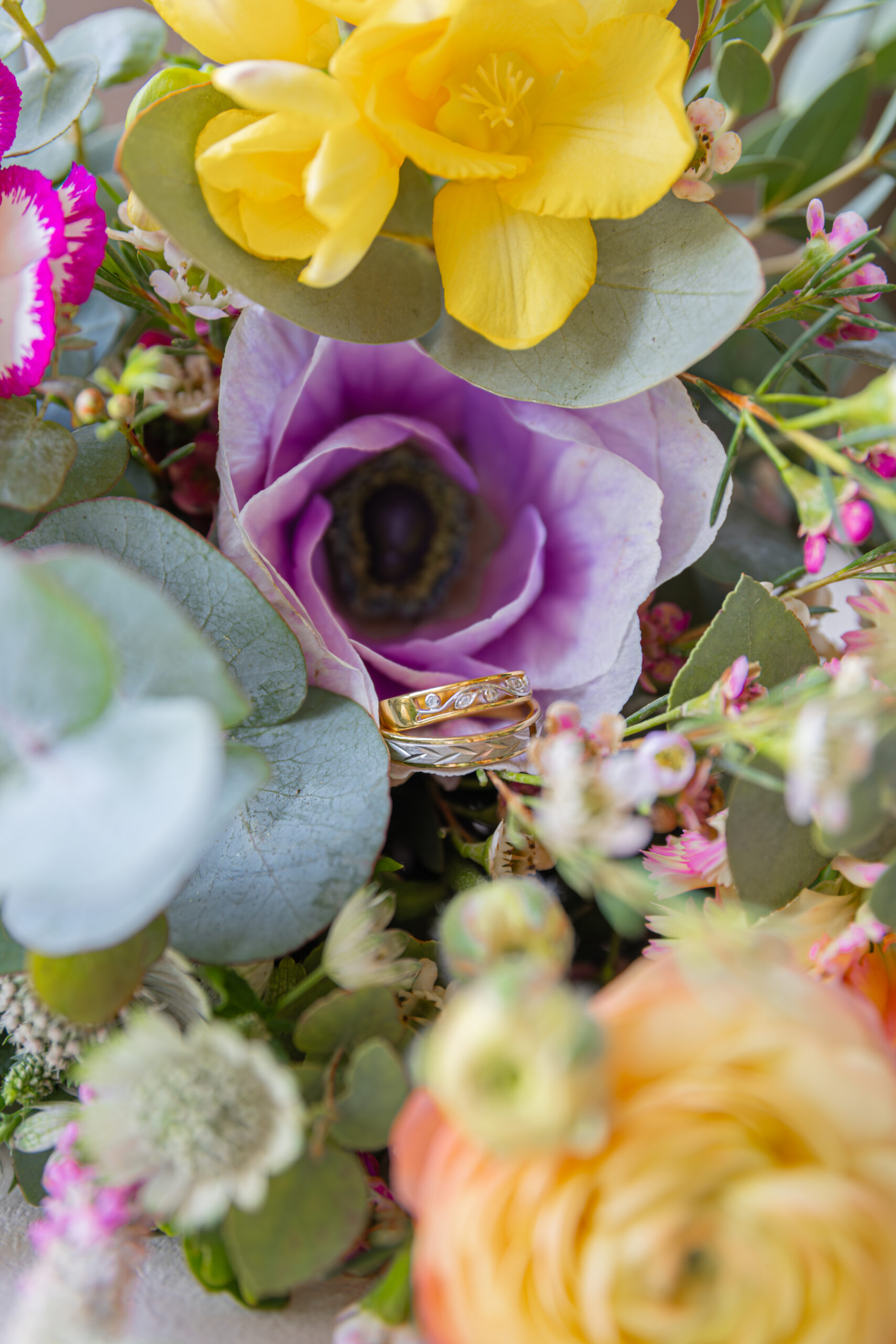 Alliances reposant dans une fleur dans le bouquet de la mariée pendant un mariage au Domaine Quatre Plumes aux Landes-Génusson en Vendée, réalisée par Solène photographe.
