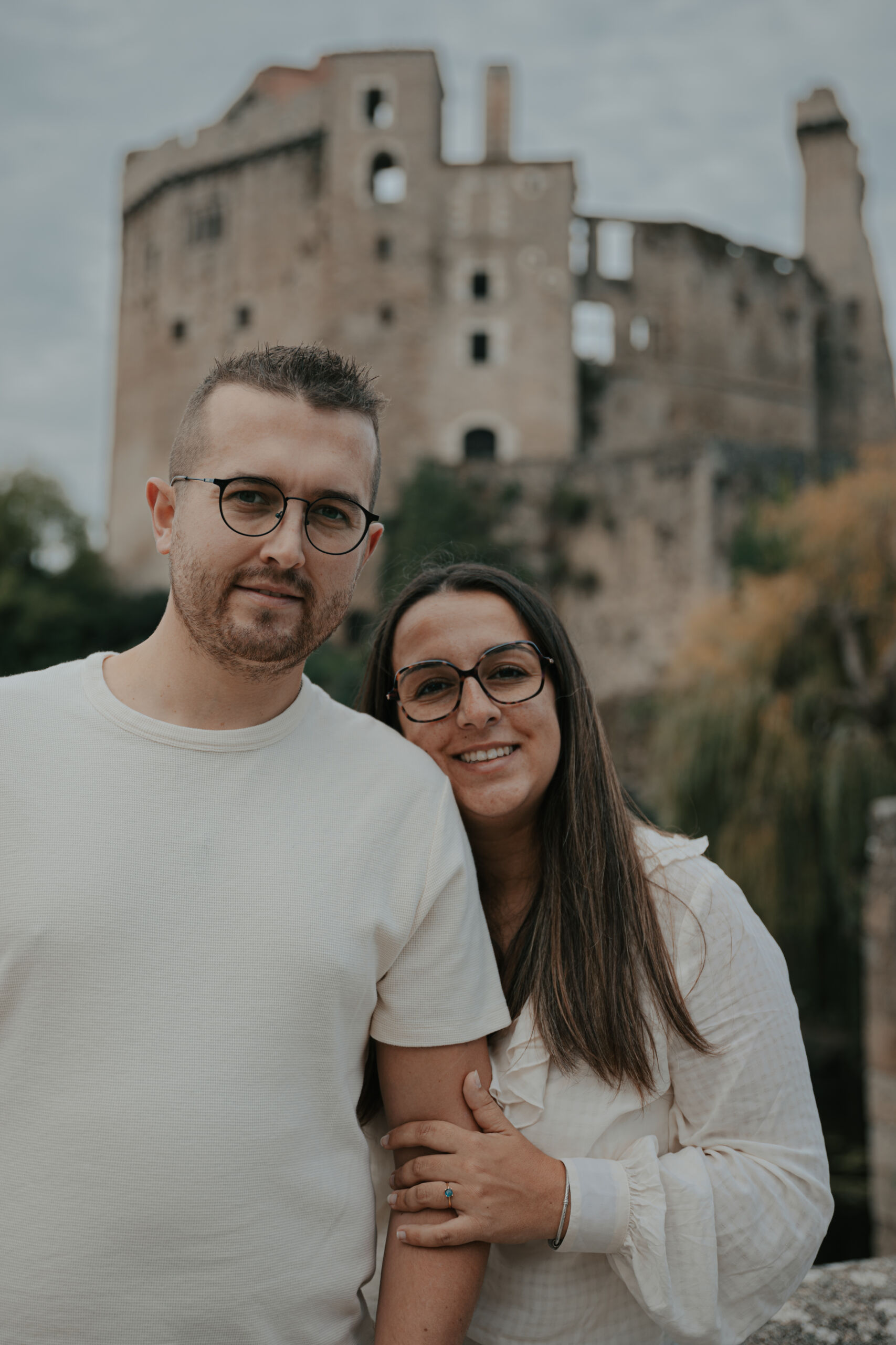 Femme se tenant derrière son conjoint en enlaçant son bras et en posant sa tête sur son épaule, lors d’une séance photo engagement à Clisson en Loire-Atlantique, réalisée par Solène photographe.