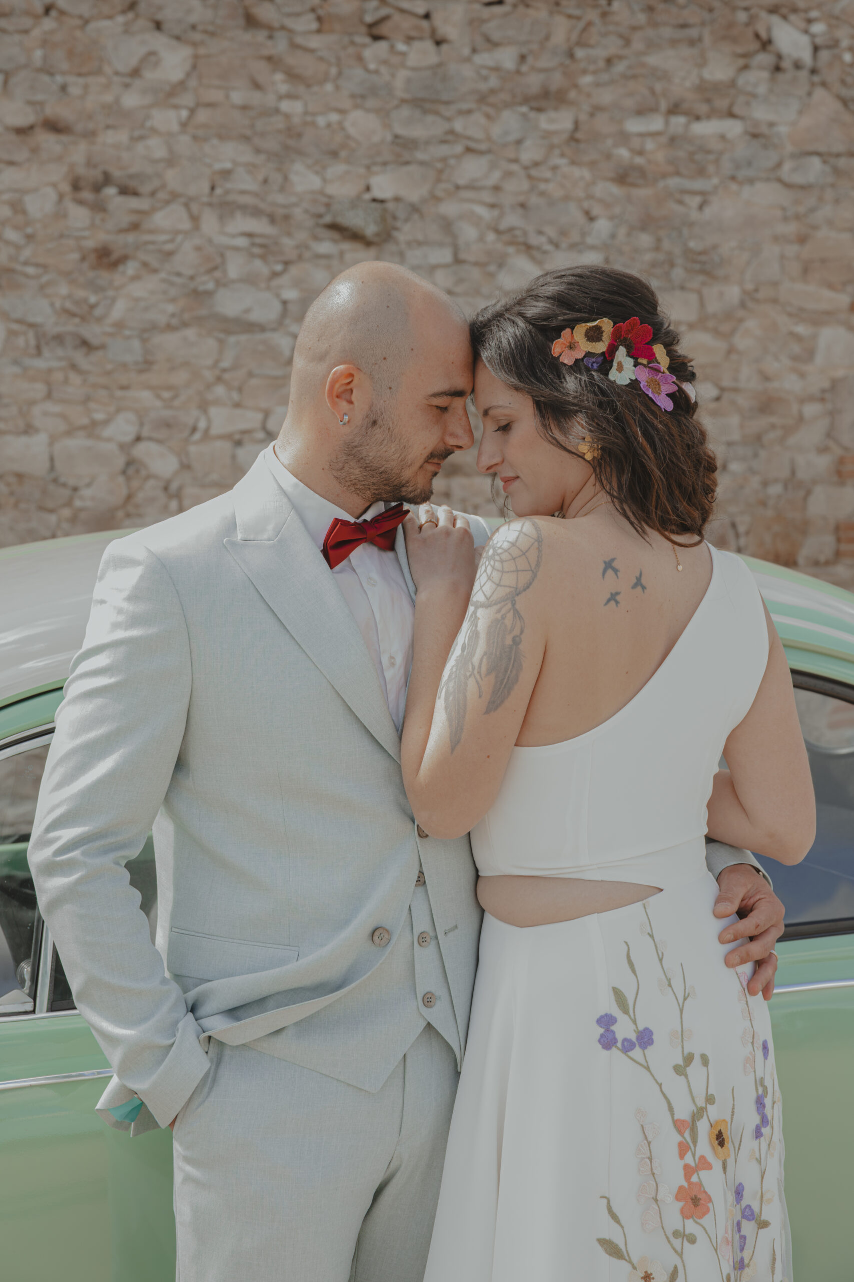 Mariés se tenant debout front contre front contre une voiture de collection, lors des photos de couple pendant leur mariage au Domaine Quatre Plumes aux Landes-Génusson en Vendée, réalisée par Solène photographe.