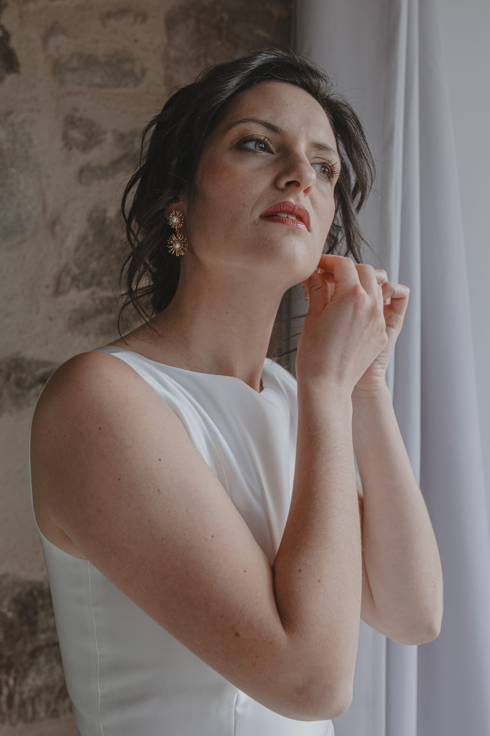 Mariée mettant sa boucle d'oreille pendant les préparatifs de son mariage, réalisée par Solène photographe.
