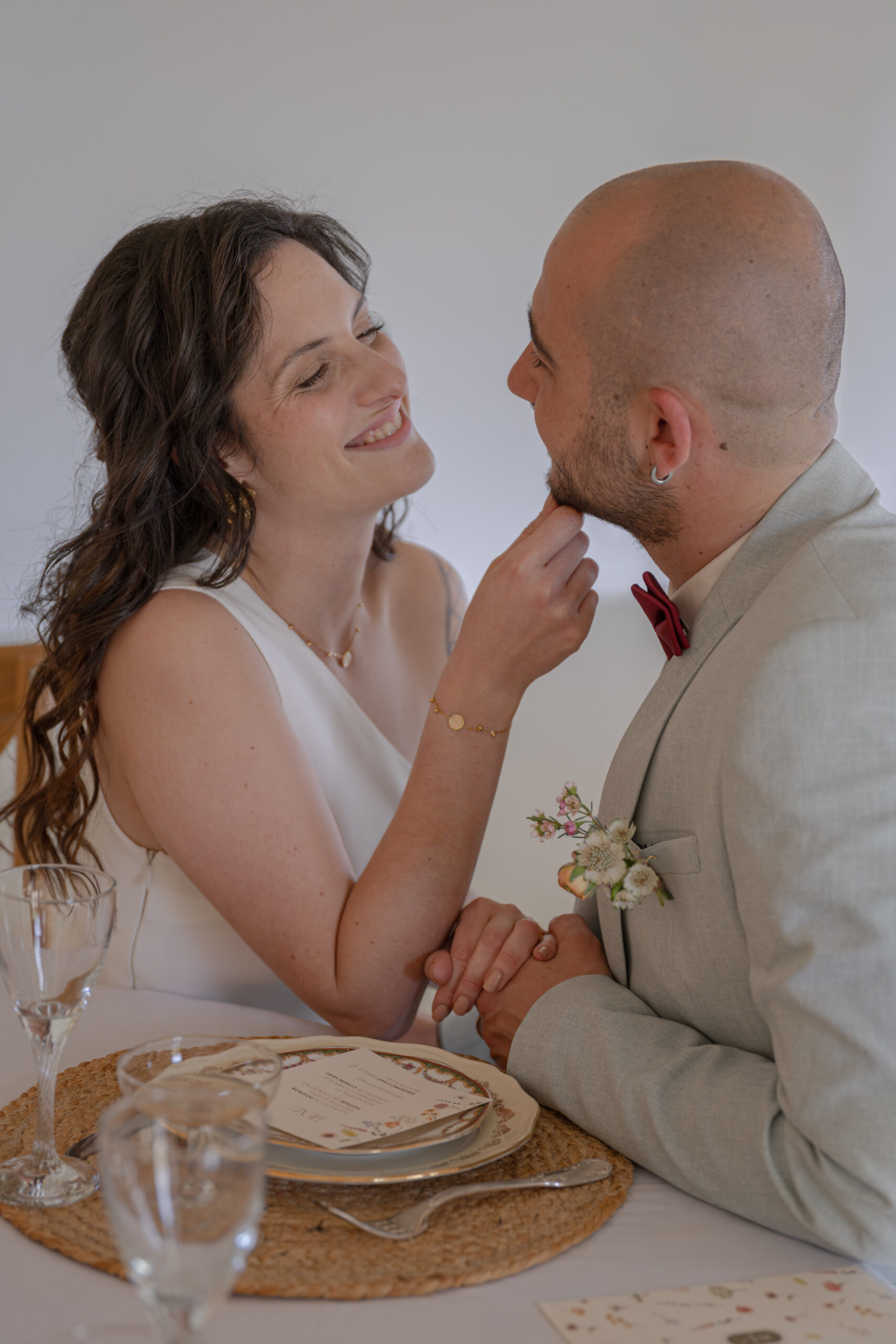 Mariés se regardant tendrement pendant le repas de leur mariage au Domaine Quatre Plumes aux Landes-Génusson en Vendée, réalisée par Solène photographe.