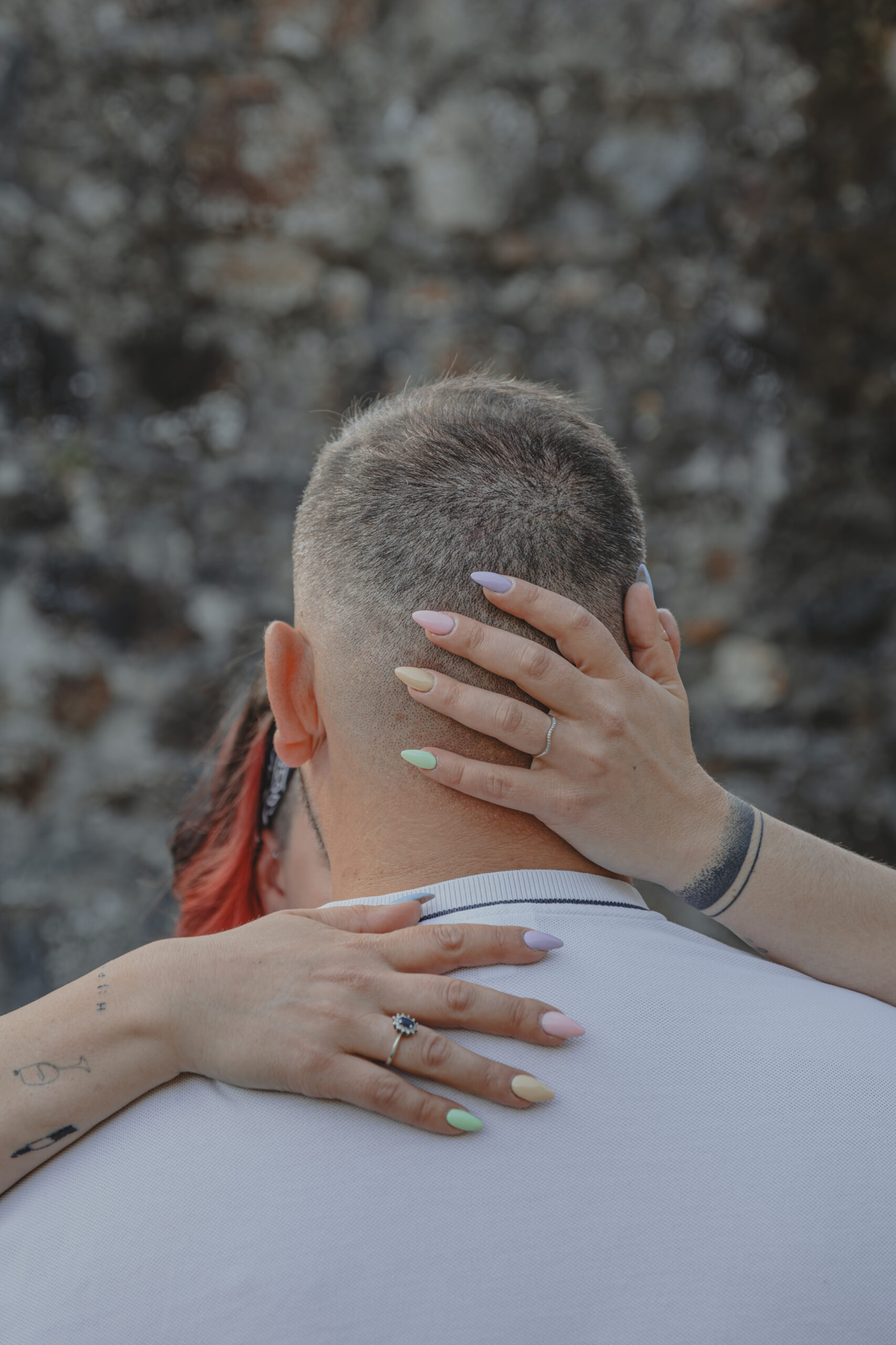 Zoom sur les mains d'une femme sur le haut du corps de son futur mari, mettant en valeur sa bague de fiançailles, lors d’une séance photo engagement au Parc des Remparts à Montaigu-Vendée en Vendée, réalisée par Solène photographe.